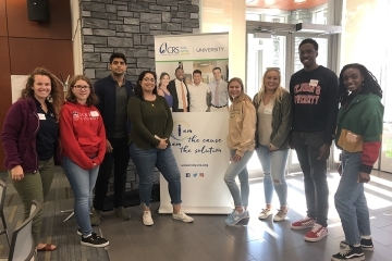 Catholic Relief Services members standing with vertical CRS banner