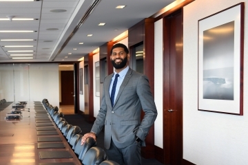 Tahir Boykin in conference room with long wood table and empty chairs