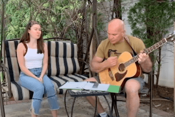 Fiona Castro singing, Joe Castro playing guitar