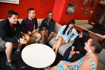 Students talking around a white table at Manhattan Campus