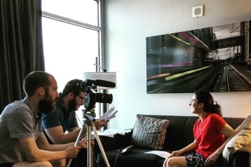 Evan Gardner and Austin filming a young woman on a couch talk for a documentary