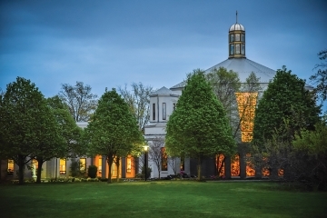 Exterior of St. Thomas More Church during the evening with its lights on
