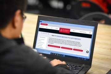 Person on laptop looking at St. John's application page.