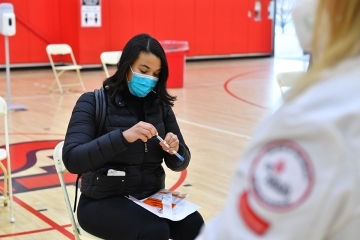 Student administering a covid-19 test with a St. John's College of Pharmacy Employee overseeing