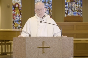 Fr Shanley speaking infront of podium
