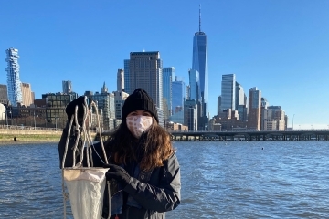 Tina Walsh on a pier with the NYC skyline behind her