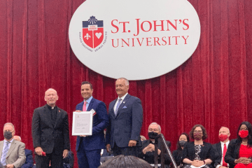 William L. Murphy, Esq. accepting an award onstage with Fr. Shanley and Dean Gerstner