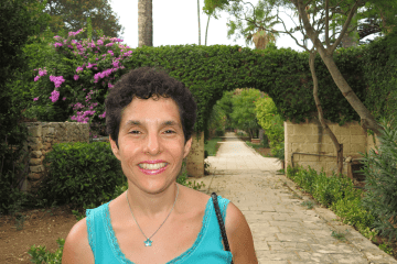Daniella Bernett with an outdoor garden and path behind her