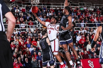 St. John’s and Providence mens basketball players shooting a basket