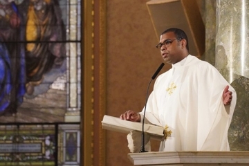Fr. Alonso Cox reading from bible at mass