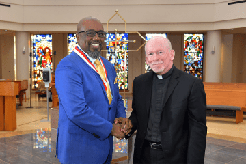 Weedens Blanchard shaking Fr. Shanley's hand