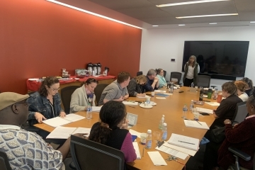 Dr. Stephanie Dunson speaking to a table full of faculty members