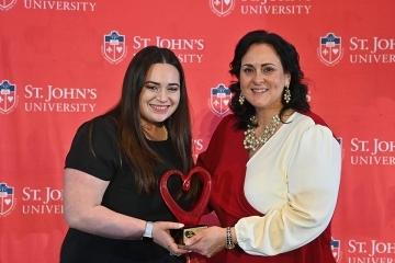 Two females holding award 