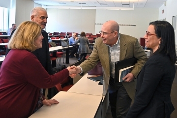 D'Angelo Chair Lecture attendees speaking and shaking hands