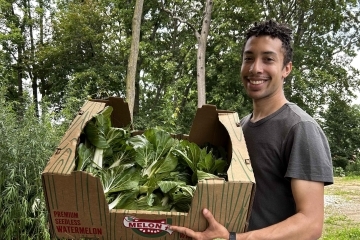 Lucas Shears carrying a carton of lettuce