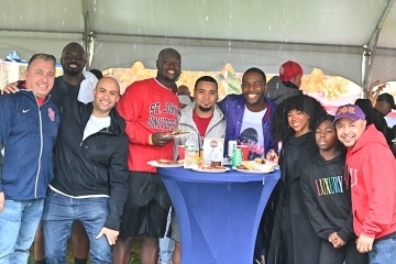 Group of St. John's Alumni gathering under tent for photo