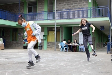 St. John's Law student Mary John's plays a hopping game in a coutyard with a little girl.