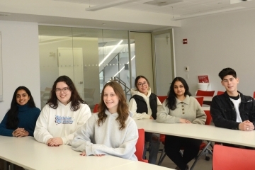 Six Tobin students pose for a photo in a classroom while seated