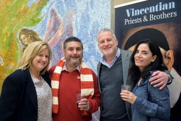 Two couples pose for a photo inside of St. Thomas More Church