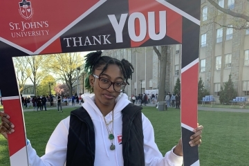St. John's Student holding a Thank You poster