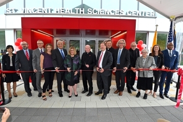 Group shot of St. Vincent Health Sciences Center ribbon cutting ceremony at building entrance 
