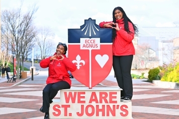Autumn hill and classmate standing on We Are St. John's statue