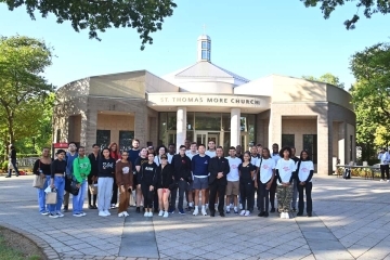 St. John's community members gather outside in front of St. Thomas More Church for a group photo