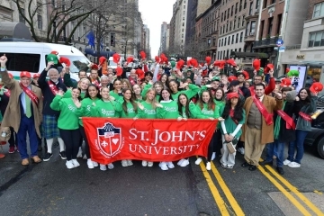 Group shot of St. John's parade attendees marching with banner