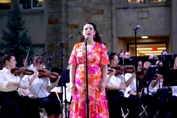 Singer performing at Great Lawn Summer Concert on Queens, NY Campus