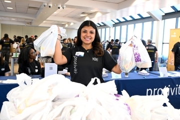 Student holding up plastic bags filled with food 