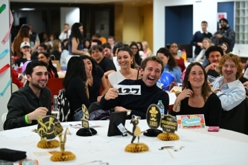 St. John's Law students sit around table participating in the Public Interest Auction.