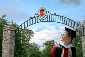 Student at commencement at St. John's University's main gate.