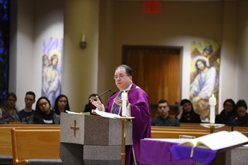 Fr. Holliday speaking in Thomas More Church