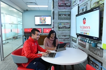 Male and female student on laptops in Homeland Security Lab