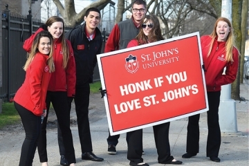 Six students holding a &quot;Honk if you Love St. John's&quot; sign