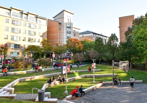 Students at outdoor basketball courts next to Residence buildings