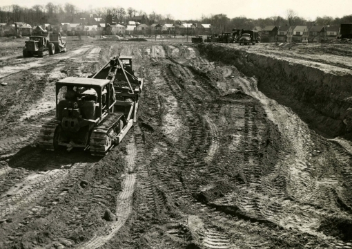 Construction trucks clearing land in 1954
