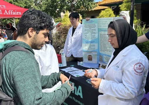 Student talking to on another at the Annual Wellness Expo Shines a Light on Resources Available to Students at St. John’s
