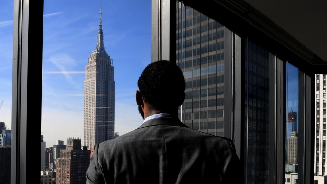 Male Student Looking Out City Window at Empire State Building