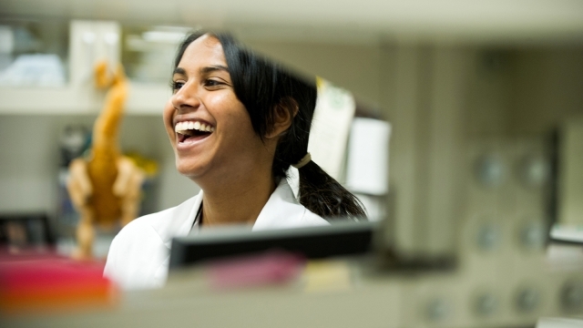 Female Student Laughing in Lab Coat 