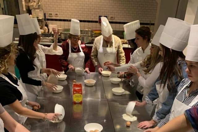 Students standing around table cooking