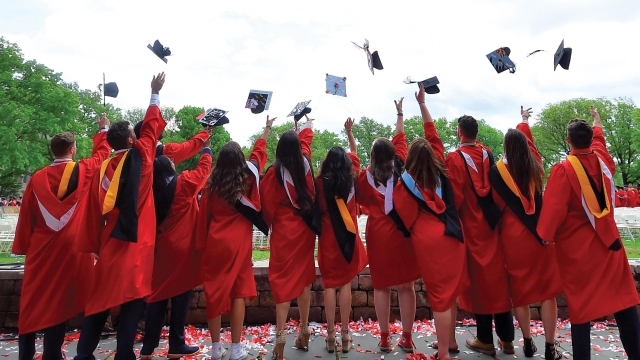 Students throwing commencement caps in air 