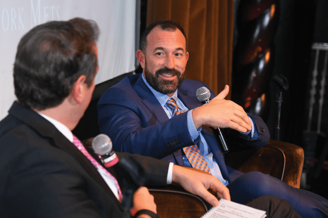 Mickey Callaway speaking into microphone to another gentleman