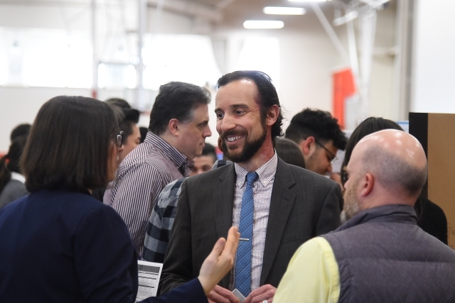 Three administrators talking at research poster presentation