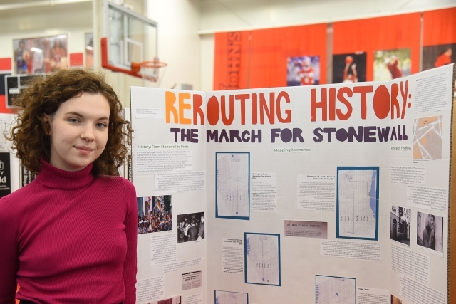 Female student standing infront of her research poster