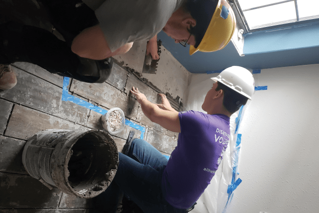 St. John’s Plunge participants install floor tiling in a house outside Houston, TX.