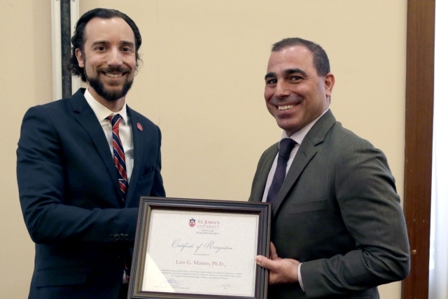 Male holding award with male administrator