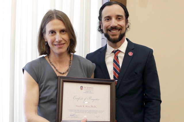 Female holding award with male administrator