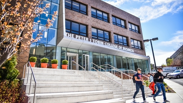 Exterior shot of Peter J. Tobin College of Business with students walking down the stairs