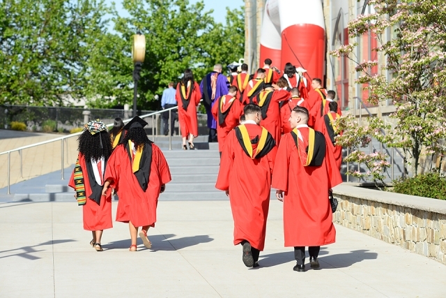 Group of students walking into Commencement ceremony in academic attire